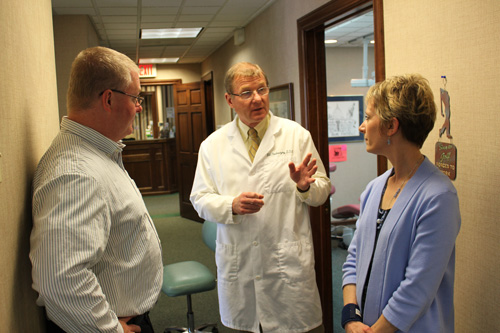 Dr Poz confers with patients at his office.