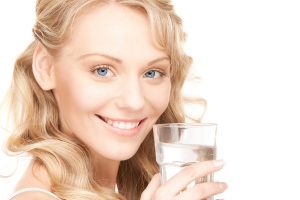 beautiful woman with glass of water over white